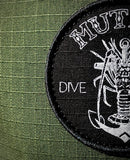Rad close up of the olive green rip stop fabric with a black patch on the Mutiny Dive Co hat.